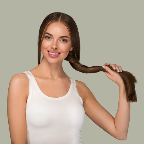 Beautiful woman with long  smooth  healthy hair tail beauty casual style. Color background green
